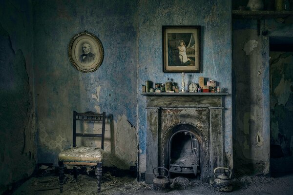 Old furniture and paintings in a room with a fireplace