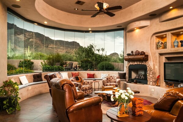 Fireplace and leather armchairs on the background of a rounded window
