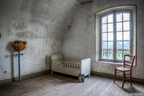 An empty room with a baby cot