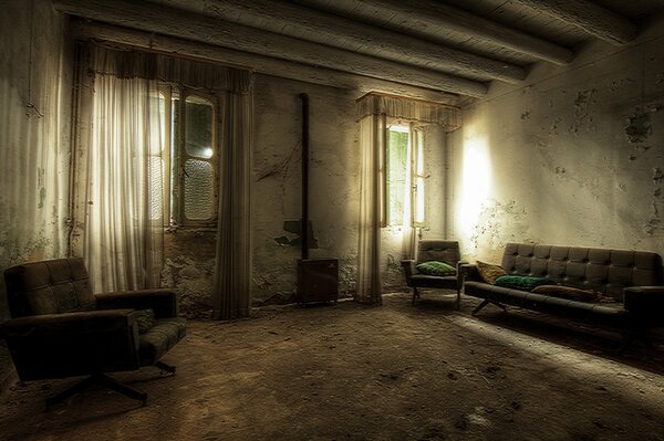Zimmer mit alten Möbeln und verdorbenen Tapeten