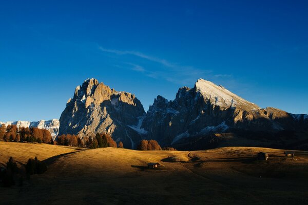 A house in the shadow of the mountains in autumn