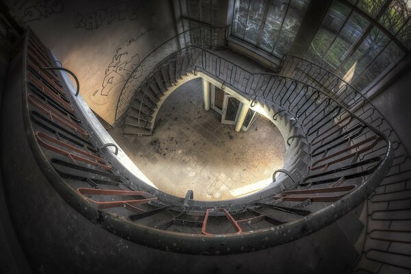 A dilapidated staircase in an old abandoned building