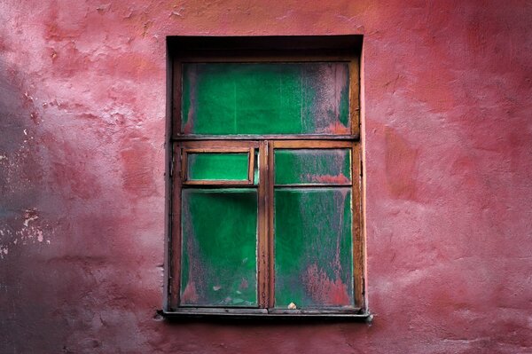 Rote Wand mit altem Holzfenster