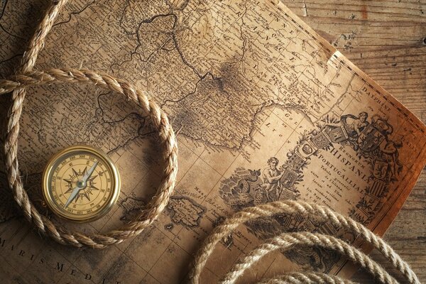 Stara mapa z leżącą na niej liną i kompasem