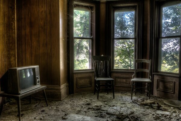 Habitación oscura con sillas de TV viejas y ventanas