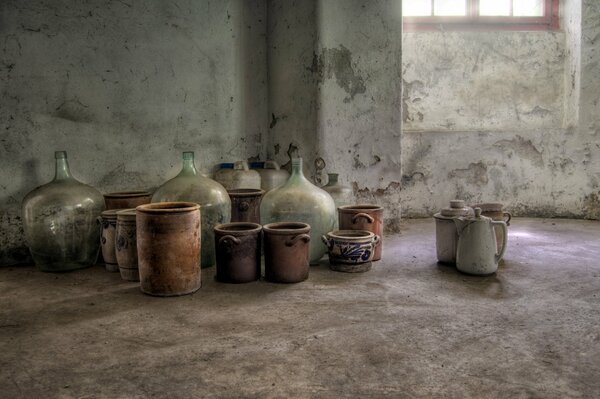 A room with large bottles and ceramic dishes