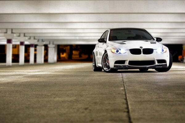 White BMW car with glowing headlights