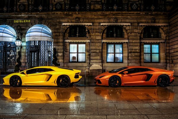 Dos hermosos autos en el fondo de un hotel nocturno