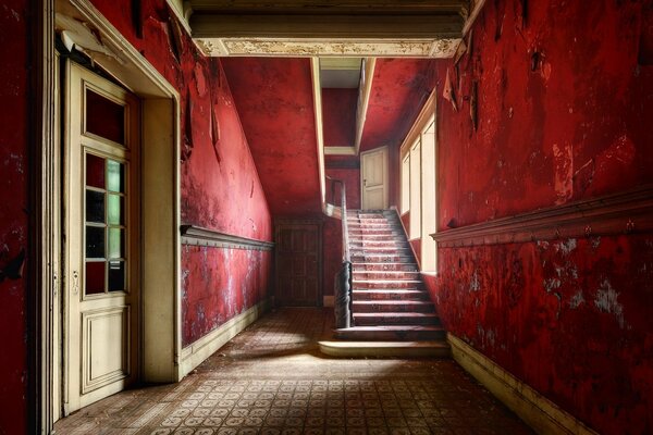 Hall aux murs rouges dans une maison abandonnée