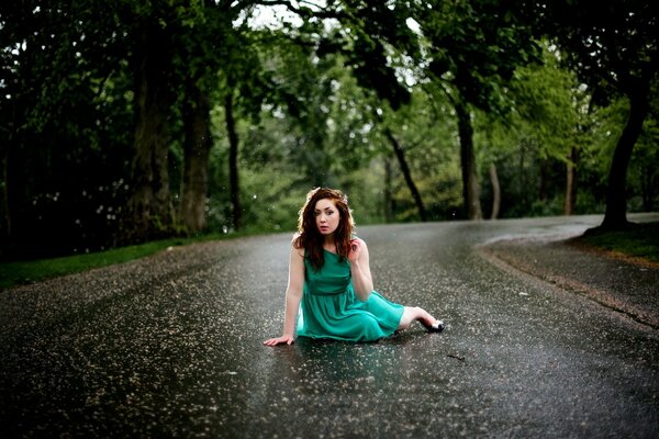 A girl in a green dress on the asphalt