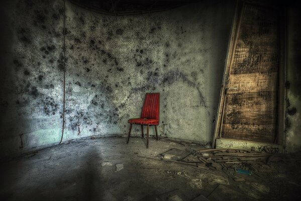 A red chair in a shabby room