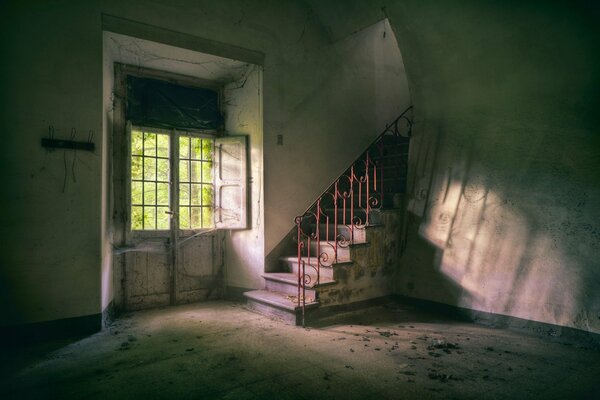 An abandoned room with stairs to the top