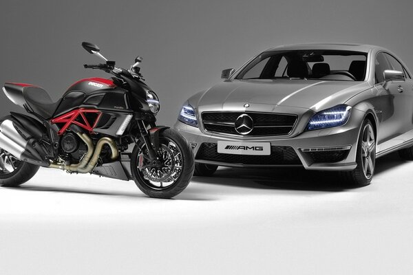 Ducati-Motorrad auf dem Hintergrund eines Mercedes-Autos