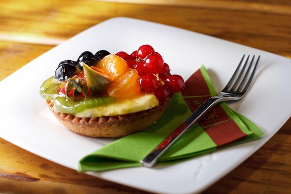 Tortino con pezzi di frutta e bacche su un piatto