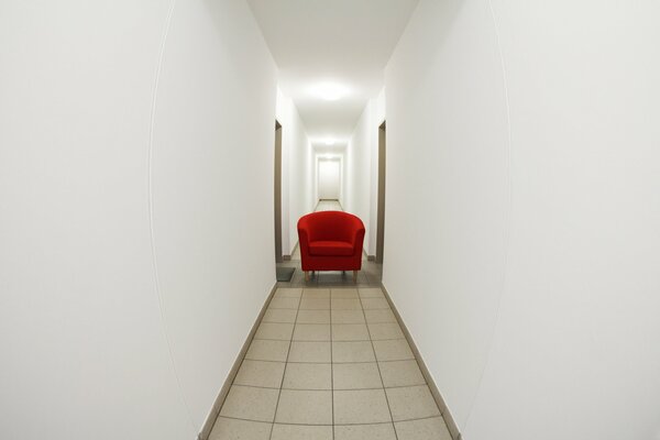 A narrow corridor and a bright armchair