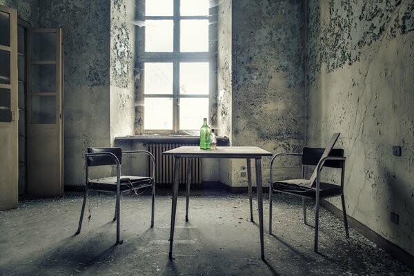 The bottle is on the table in a shabby room