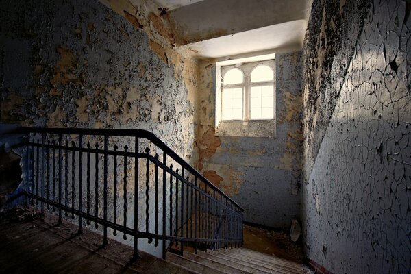 Treppe vor dem Hintergrund der abplatzenden Farbe an den Wänden