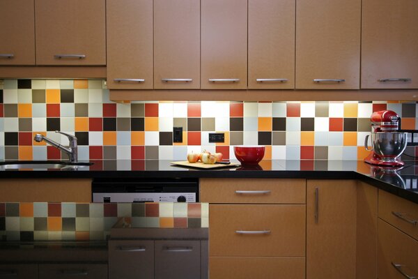 Bright kitchen with colored dishes and colorful tiles on the wall