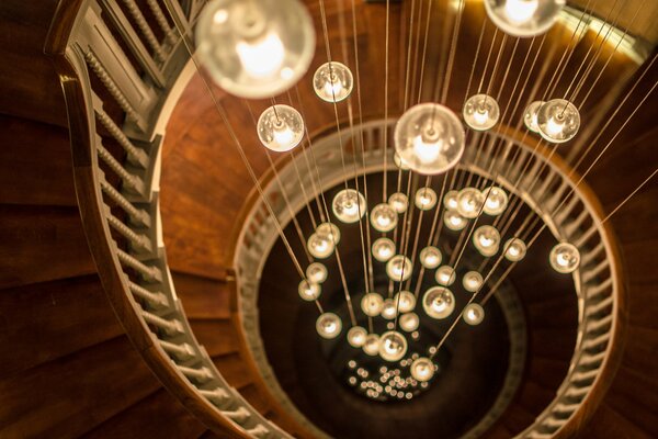 Wendeltreppe mit runden Glühbirnen an den Fäden