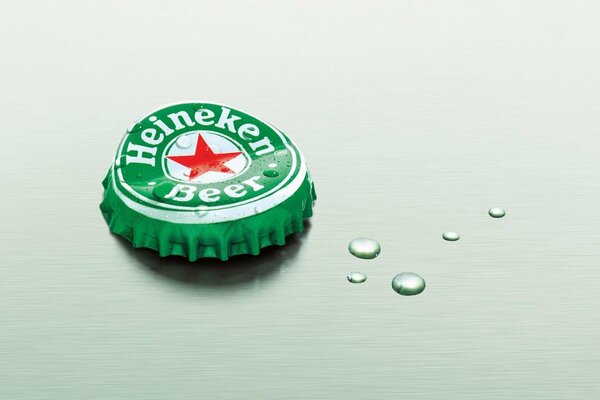 Крышка от бутылки пва Heineken с каплями конденсата на мятном фоне