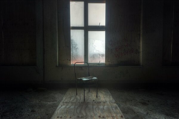 A lonely chair near the window in a dark room