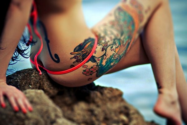Fille avec un tatouage sur une belle jambe