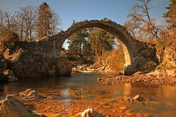 Ancient bridge over the river in autumn