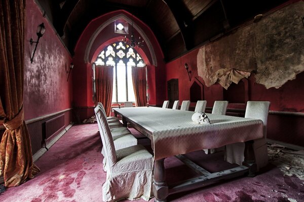 Tavolo da banchetto in bianco nella sala di velluto rosa di un antico castello