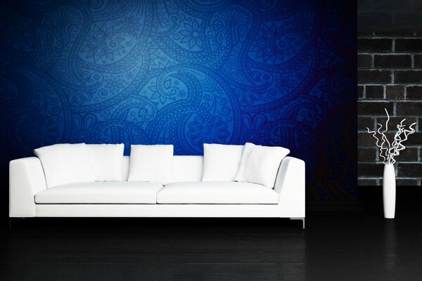 White sofa on a dark background with a vase