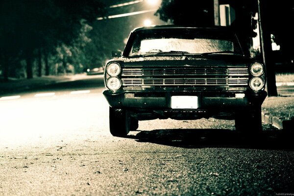 Coche antiguo en la carretera nocturna