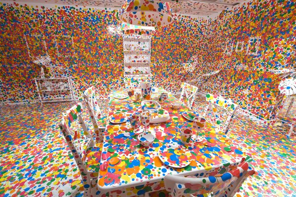 Salle blanche avec des meubles blancs décorés avec des tasses multicolores