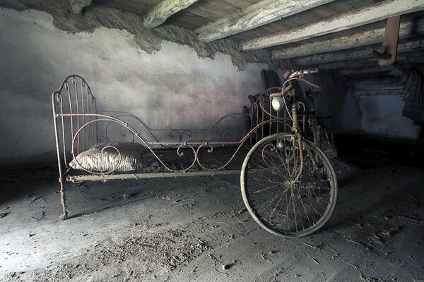 An old dusty attic with a bed and a bicycle