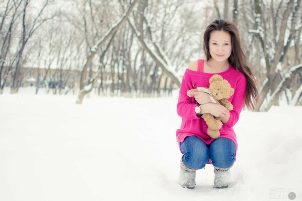 Chica con oso de peluche en invierno