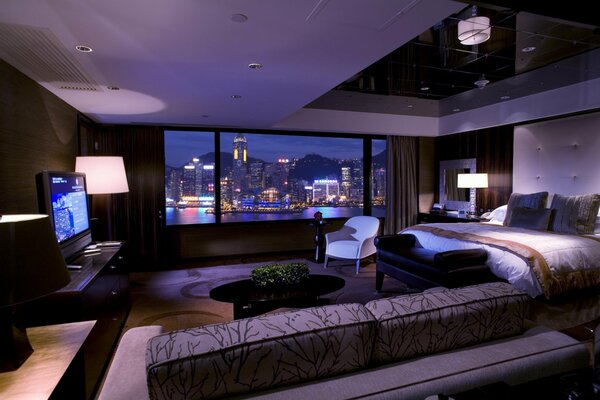 Elegante interior de la habitación con vistas a la ciudad nocturna desde la ventana