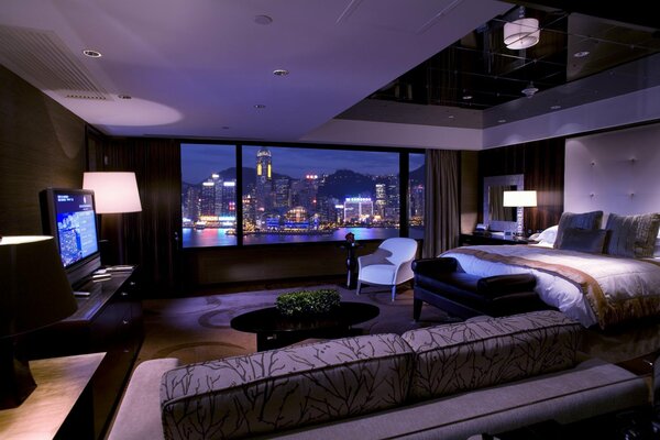 Стильный интерьер комнаты с видом ночного города из окна