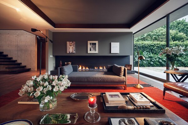 Interior of the living room with a large fireplace and sofa in the villa in the garden