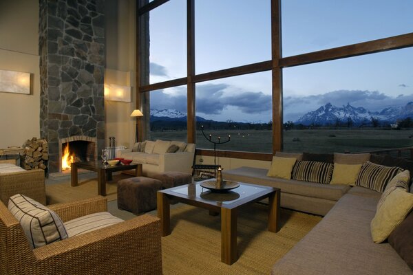 Уютная комната с камином и горным пейзажем за окном