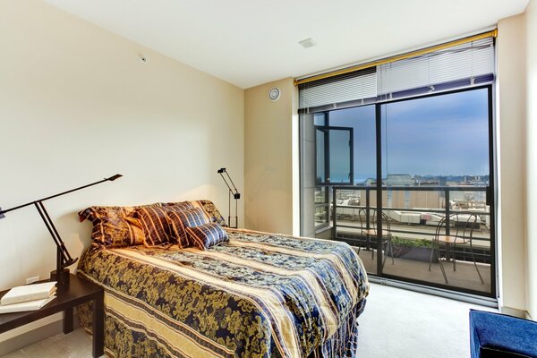 Intérieur chambre avec lit et balcon