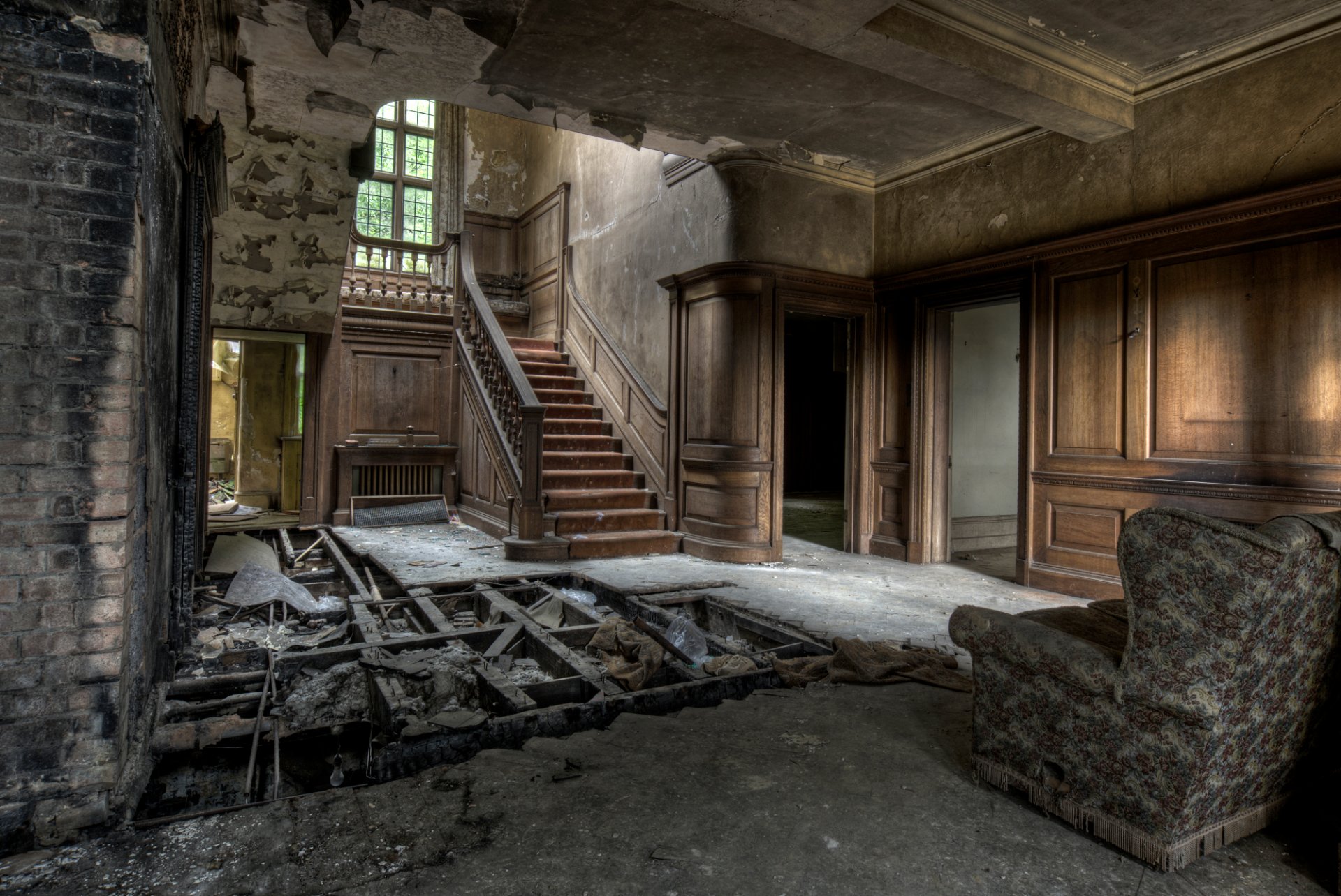 ruina casa abandonada pisos destruidos paredes sin pintar sillón escaleras madera paredes de ladrillo ventana puerta pre-tipo techo y paredes en mal estado