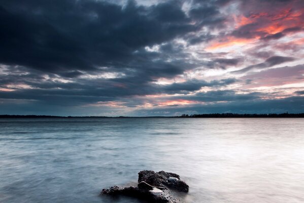 A lonely stone in the middle of the lake cloudy in the afternoon