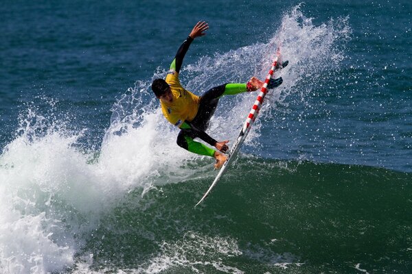 Surf. Hombre saltando sobre una ola con una tabla