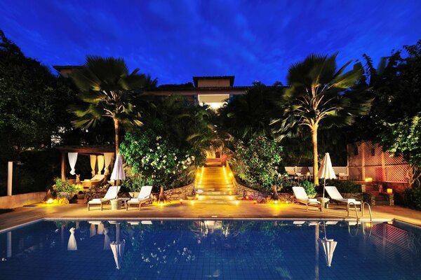 Vista nocturna de la piscina en el hotel