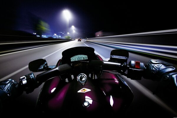 A motorcyclist rides through the night city