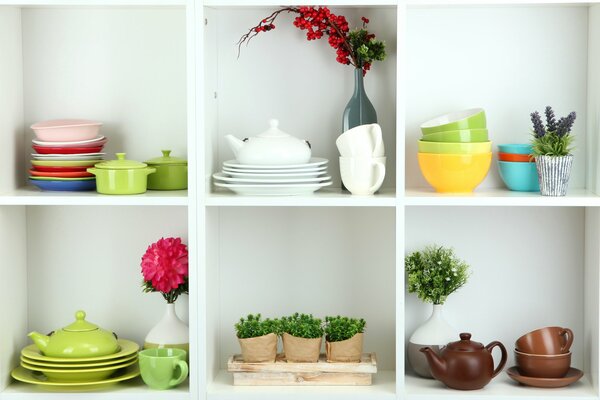 Półki z naczyniami, kwiatami, gałęziami w wazonach