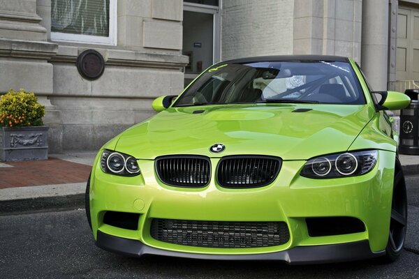 Зелёный BMW тюнингованный у стены