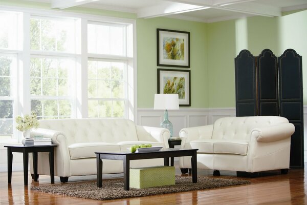 Paredes verdes, sofás blancos y una gran ventana