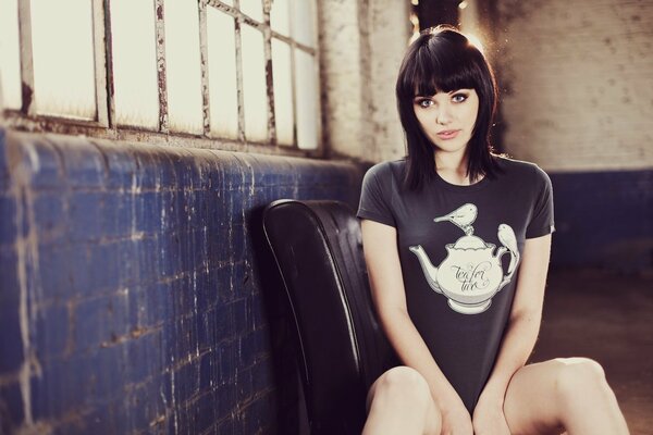 Brunette in the garage in a long T-shirt with a print