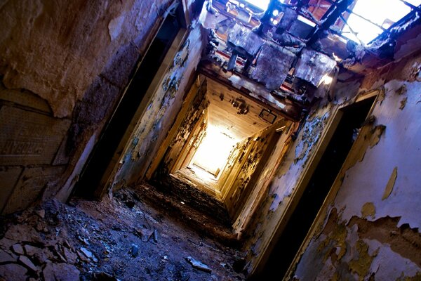 Verwüstung , Schmutz und Licht am Ende des Tunnels. Das Dach der Halle ist gefallen. Peeling mit einer Standheizung in der Tür