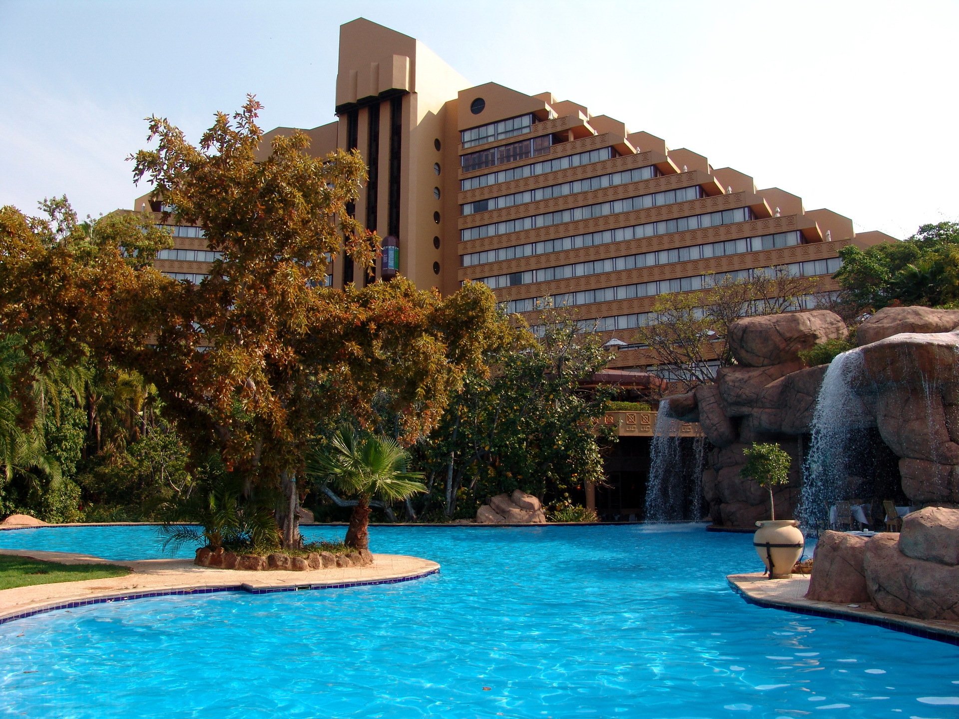 hotel sun city sur áfrica diseño arquitectura piscina rocas cascada palmeras árboles