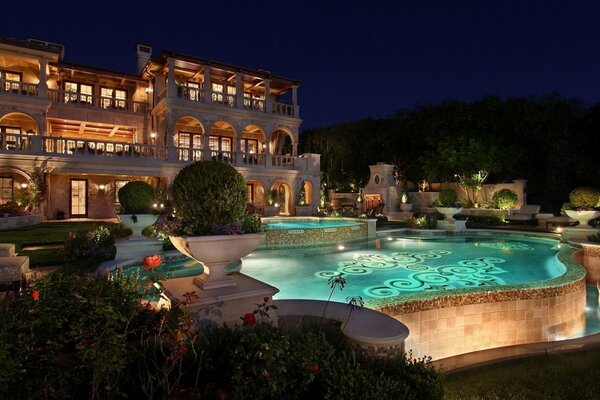 Casa en la noche y piscina iluminada